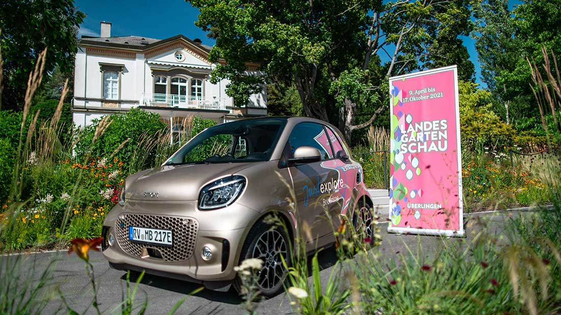 Ein smart von Autohaus Riess steht in Überlingen vor einem Rollup zur dortigen Landesgartenschau